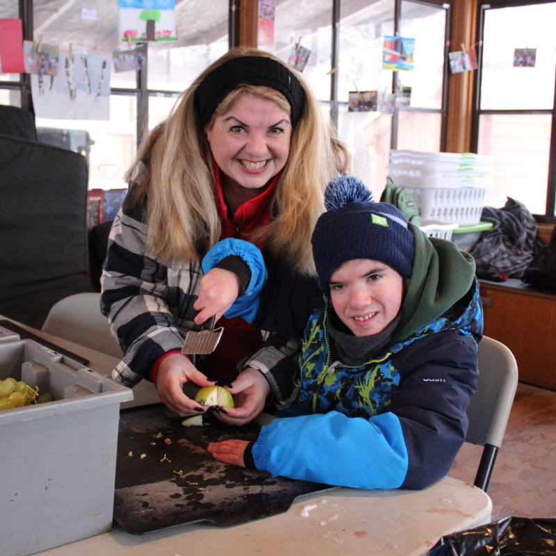 Maria and a guest cutting vegetables.
