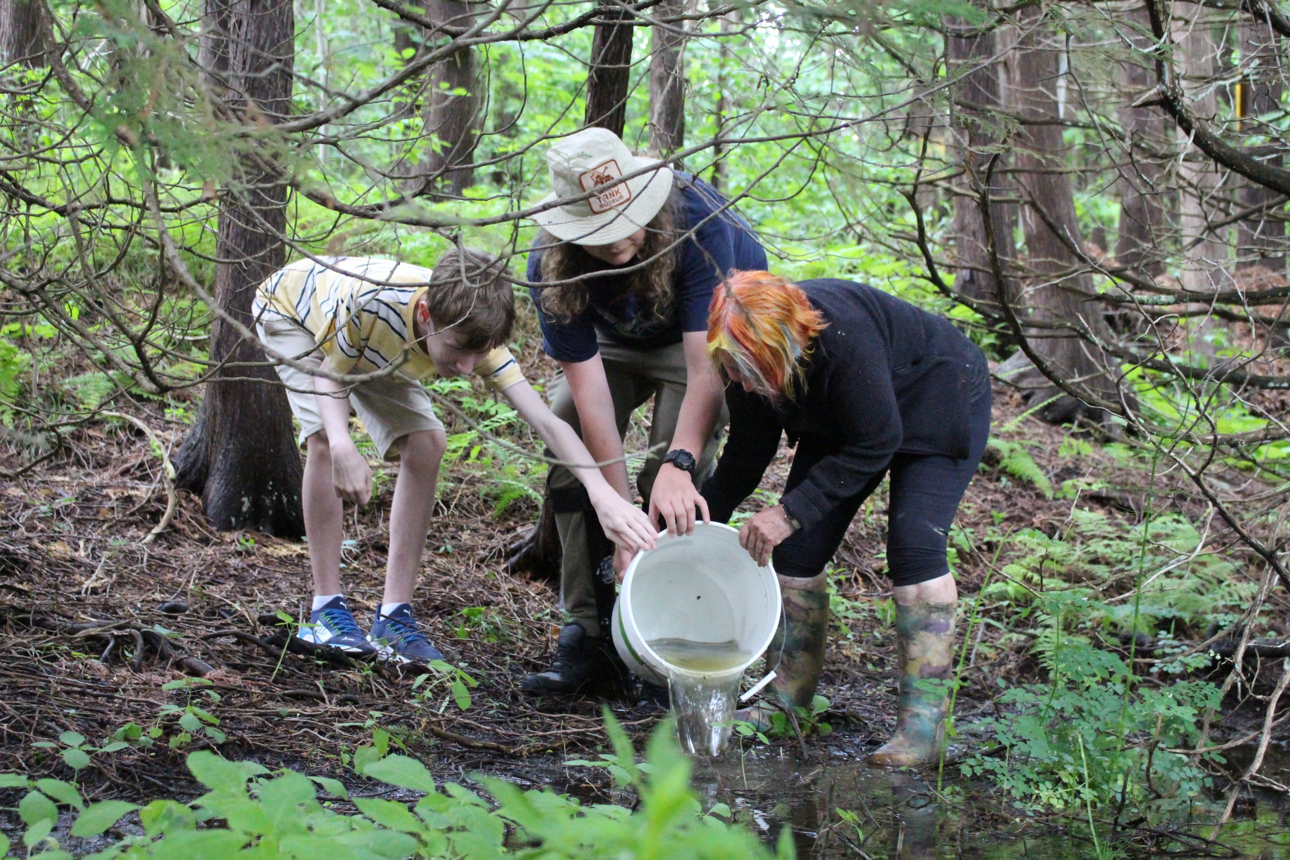 Participants and mentors putting water back into the creek.